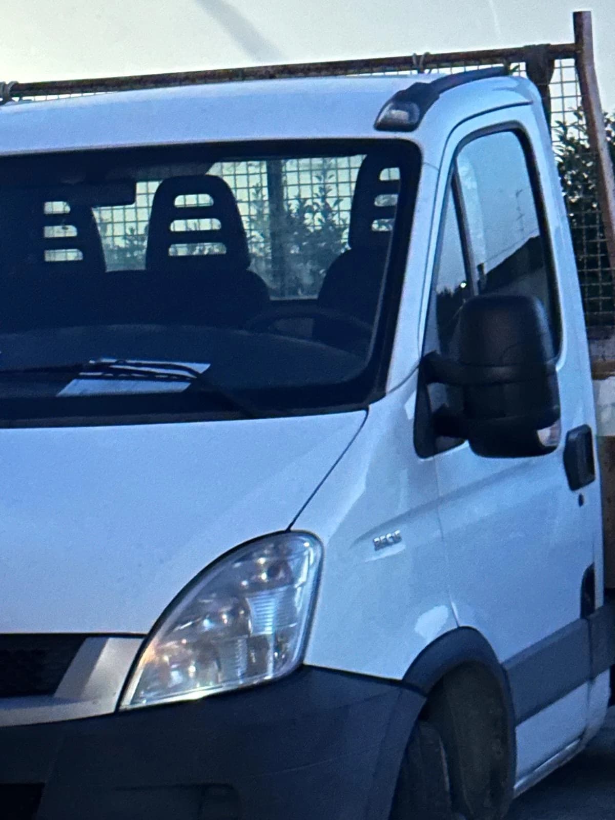 Parte anteriore e cabina laterale di un furgone bianco da lavoro.