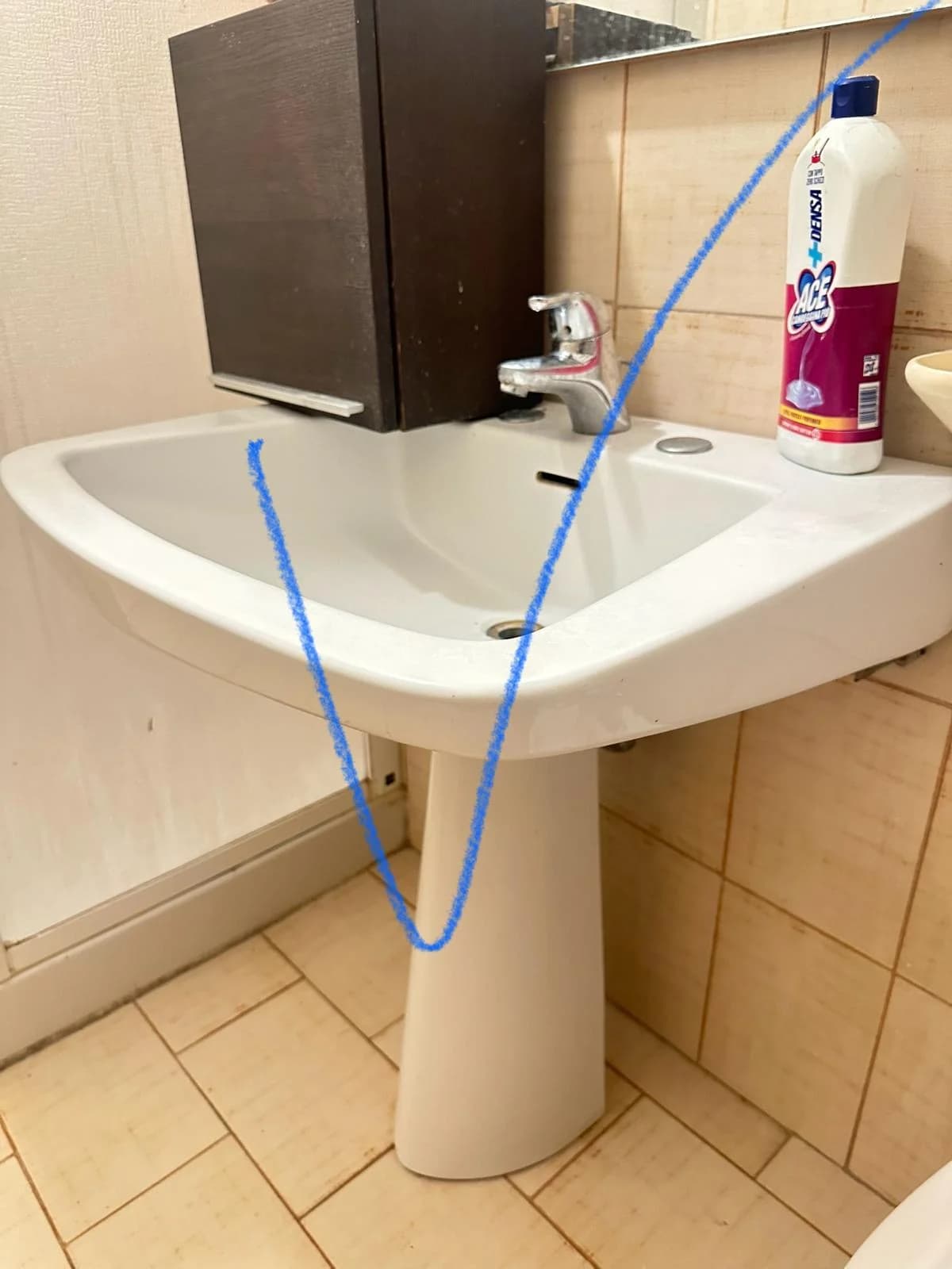 Lavabo a colonna con rubinetto in un bagno piastrellato.