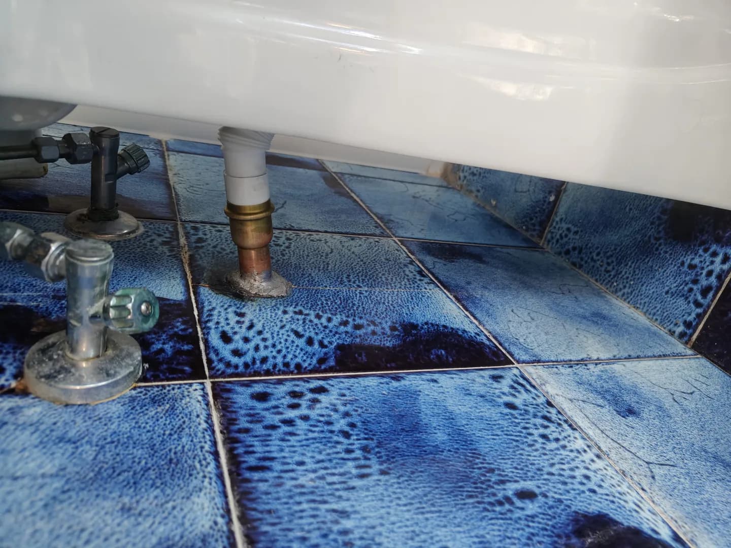 Scarico del lavabo riparato con un nuovo collegamento metallico, senza rompere le piastrelle.